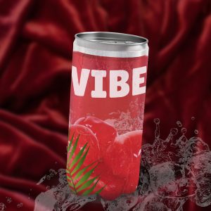 Une canette de boisson VIBE sur un fond de tissu rouge et entourée d'éclaboussures d'eau. La canette est rouge, avec des cerises et une feuille de palmier sur l'étiquette. C'est une maquette publicitaire.