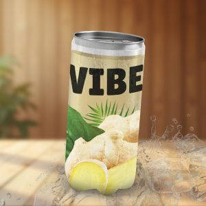Une canette de boisson VIBE sur une table en bois et entourée d'éclaboussures. La canette est beige, avec des feuilles vertes, une tranche de citron et du gingembre sur l'étiquette. Le nom du produit VIBE est en gros caractères noirs. L'image est une maquette publicitaire.