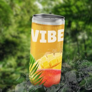 Une canette de boisson VIBE, jaune, sur un glaçon et avec de la végétation en arrière-plan. L'étiquette est ornée de feuilles de palmier et de mangue coupée en dés. L'inscription VIBE est en gros caractères blancs sur la canette. L'image est une maquette publicitaire.